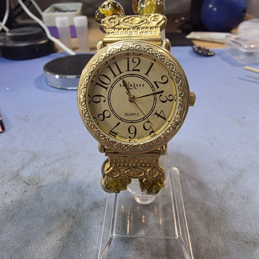 The item shown is an L.A. Express West gold-tone quartz watch
